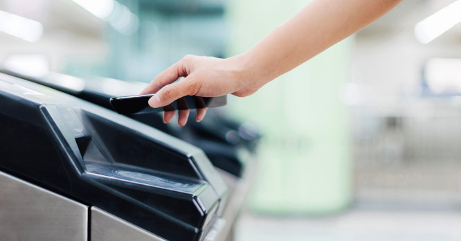 Persona utilizando su móvil para realizar un pago sin contacto en un lector electrónico, representando el uso seguro de un digital wallet para llevar tarjetas en el teléfono.